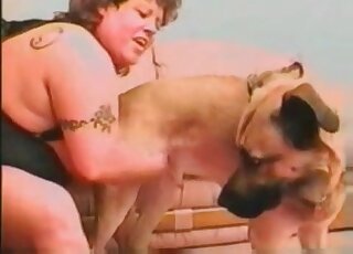 Chubby MILF dressed in black fucks a dog after giving it a handjob