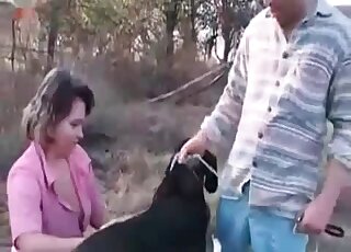 Good-looking chubby babe teasing a black dog in an outdoor vid